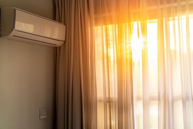A wall-mounted air conditioner unit positioned away from direct sunlight. A wall-mounted air conditioner unit positioned away from direct sunlight.