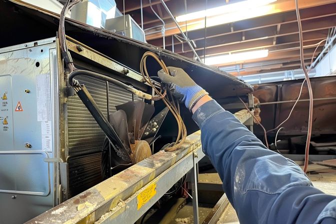 A professional technician conducting a chemical overhaul on an air conditioning unit. A professional technician conducting a chemical overhaul on an air conditioning unit.