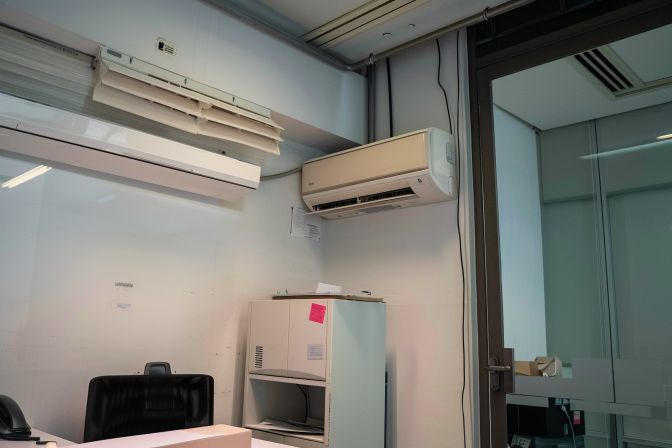 The worn-out air conditioner unit highlights the costly nature of repairs. The worn-out air conditioner unit highlights the costly nature of repairs.