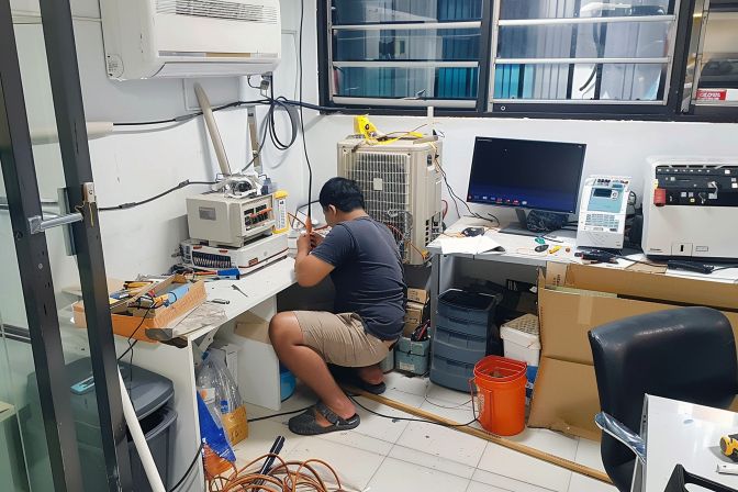 A technician is installing an air conditioning unit in a small office. A technician is installing an air conditioning unit in a small office.