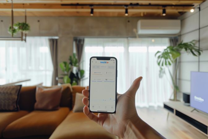 A modern living room with a smart air conditioning system displayed on a phone. A modern living room with a smart air conditioning system displayed on a phone.
