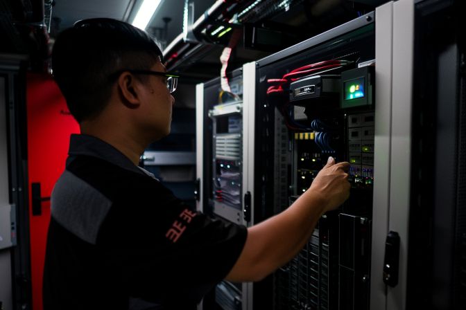 A commercial aircon technician conducting maintenance in a server room. A commercial aircon technician conducting maintenance in a server room.