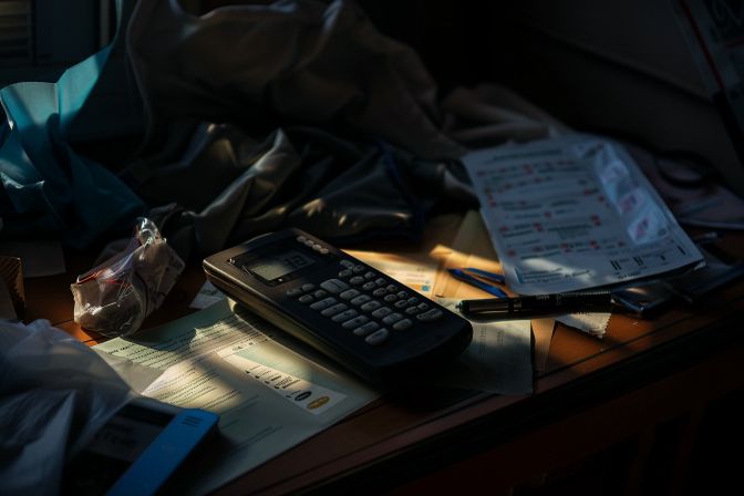 A dusty air conditioning remote with dead batteries on a cluttered table. A dusty air conditioning remote with dead batteries on a cluttered table.