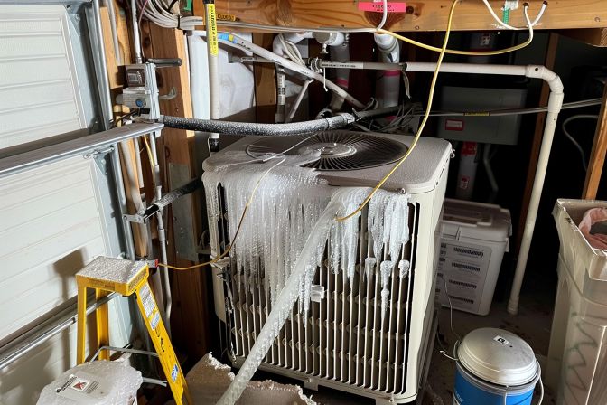 A residential air conditioning unit with visible signs of refrigerant leak. A residential air conditioning unit with visible signs of refrigerant leak.