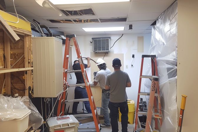 A team of experts installing an air conditioning unit in an office. A team of experts installing an air conditioning unit in an office.
